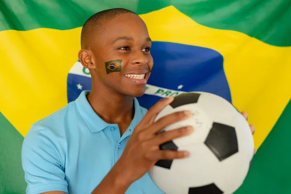 ブラジルとサッカーの旗を持つ幸せなアフリカ系アメリカ人男性ティーンエイジャー 質の高い時間を家だけで過ごす — ストック写真