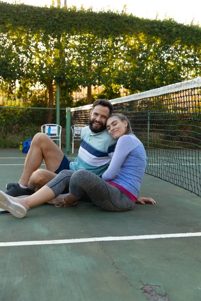 Happy Caucasian Couple Sitting Outdoor Tennis Court Net Embracing Playing — Stock Photo, Image