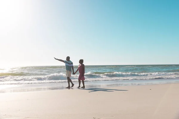 アフリカ系アメリカ人の先輩夫婦が手を取り合い 夏は澄んだ青空の下で海岸を歩く コピースペース ビーチ 変更されていない 一緒に 楽しさと自然コンセプト — ストック写真