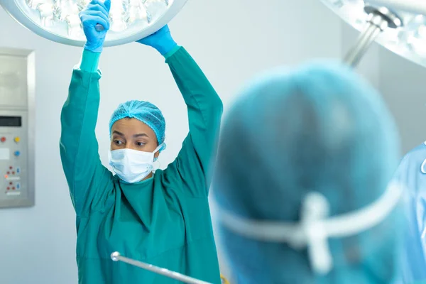 Biracial Női Sebész Kolléga Beállítja Fényeket Műtőben Műtéthez Kórházi Orvosi — Stock Fotó