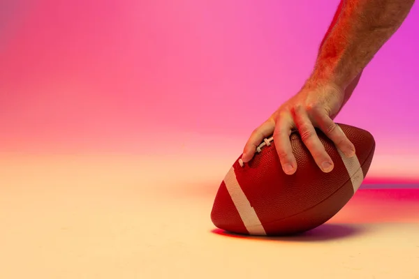 Hand Kaukaski Mężczyzna Amerykański Piłkarz Trzyma Piłkę Neonowym Różowym Oświetleniem — Zdjęcie stockowe