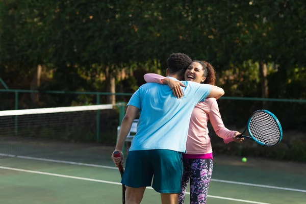 Glimlachend Biraciaal Echtpaar Spelen Tennis Omarmen Outdoor Tennisbaan Inclusiviteit Sport — Stockfoto