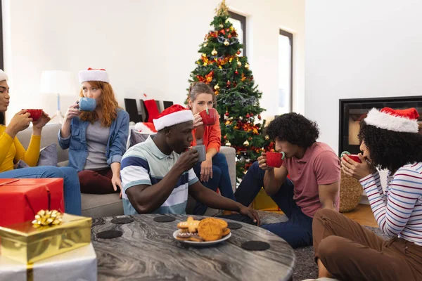 クリスマスにサンタの帽子を飲むコーヒーと幸せな多様な友人 クリスマス お祝い 包容力とライフスタイルの概念 — ストック写真