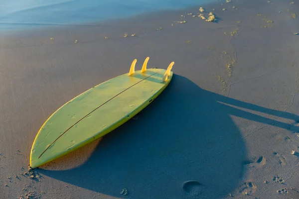 Wysoki Kąt Widzenia Żółtej Deski Surfingowej Piaszczystej Plaży Brzegu Podczas — Zdjęcie stockowe