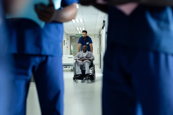 アフリカ系アメリカ人男性を車椅子で入院させる多様な男性医療従事者 医療サービス — ストック写真