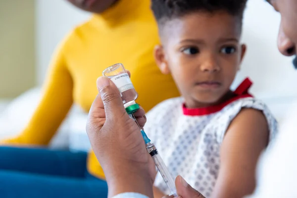 아프리카 미국인 의사가 환자를 백신을 준비하고 엄마는 병원에 있습니다 서비스 — 스톡 사진