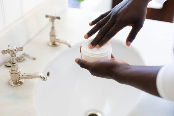 Händerna Afrikansk Amerikansk Man Använder Fuktighetskräm Ansiktskräm Vid Handfat Badrummet — Stockfoto