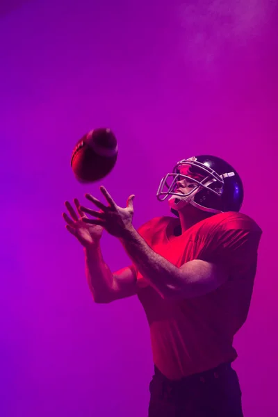 Biały Mężczyzna Amerykański Piłkarz Trzymający Piłkę Neonowym Niebieskim Fioletowym Oświetleniem — Zdjęcie stockowe