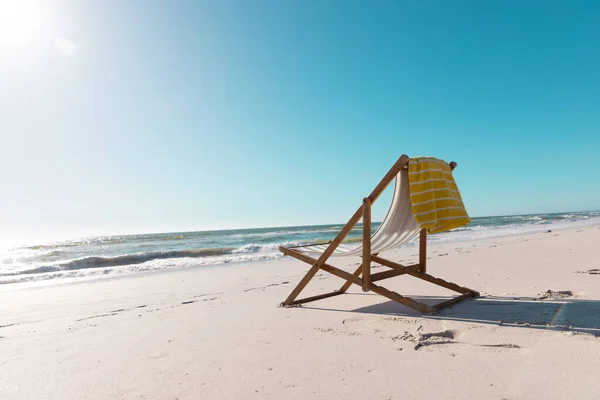 晴れた日には澄んだ青い空の下で砂浜に黄色のナプキンで空のデッキチェア 変更されていない コピースペース 自然と休暇の概念 — ストック写真