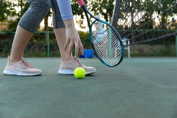 テニスラケットを持っている女性の低セクションは コピースペースで 屋外テニスコートでボールを拾う スポーツ 健康的な趣味 フィットネス 余暇時間の概念 — ストック写真
