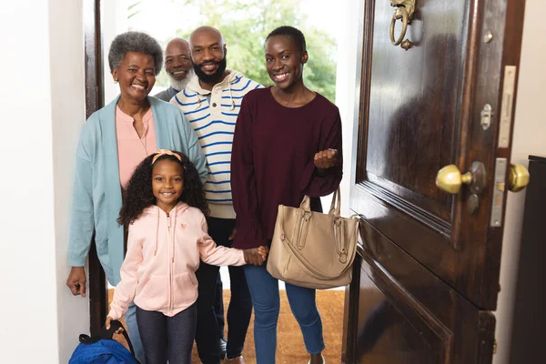 Image of happy multi generation african american family entering house. Extended family, spending quality time together concept.