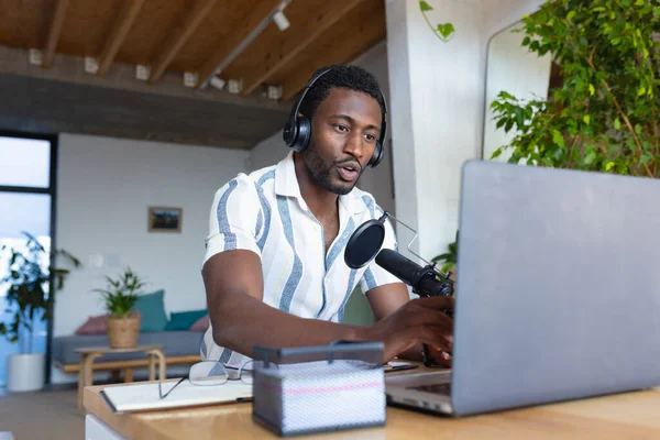 快乐的非洲裔美国人坐在厨房的餐桌旁 使用笔记本电脑 制作博客 独自在家度过高质量的时光 — 图库照片