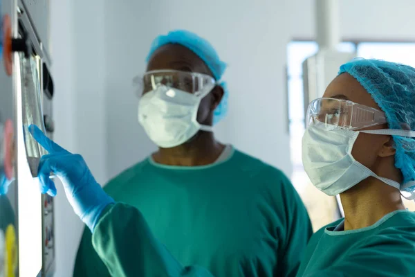 Dois Cirurgiões Diversos Discutindo Raios Lightbox Sala Operações Serviços Hospitalares — Fotografia de Stock
