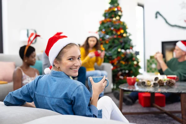 ホットチョコレートを飲む友人と自宅でクリスマスを祝う幸せな白人女性のイメージ クリスマス お祝い 包括性とライフスタイルの概念 — ストック写真