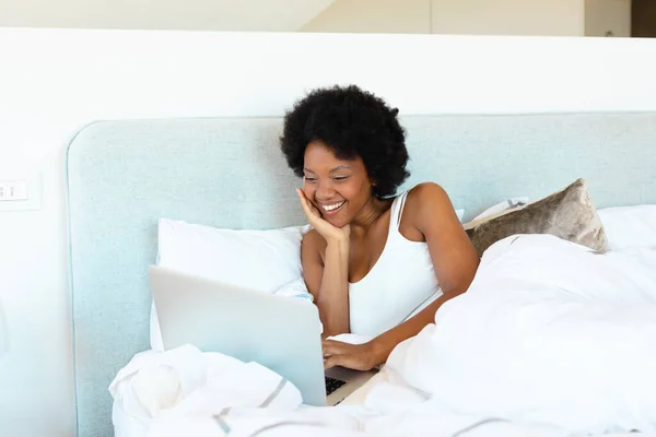 Glimlachende Jonge Afrikaans Amerikaanse Afro Vrouw Met Laptop Comfortabel Bed — Stockfoto
