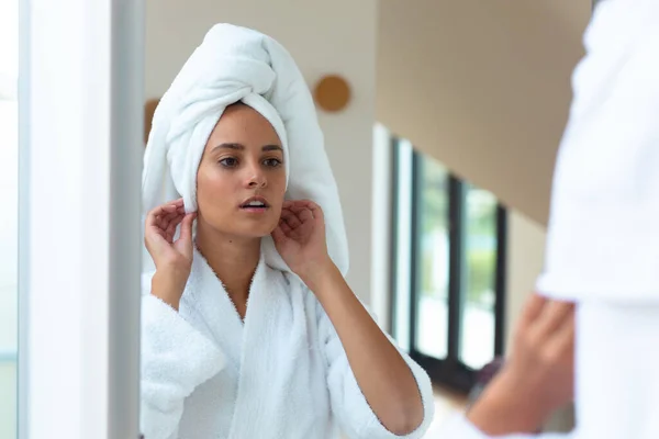 穿着浴衣的白人女人在家里看着镜子里自己的倒影 自我照顾 卫生和放松的概念 — 图库照片