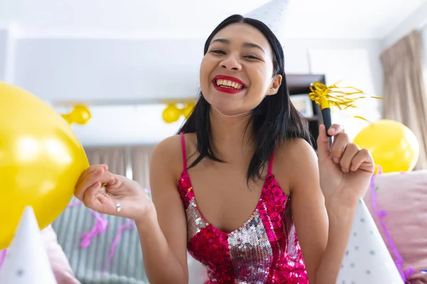 stock image Happy biracial woman having party at home making video call and smiling, copy space. Celebration, party and communication concept.