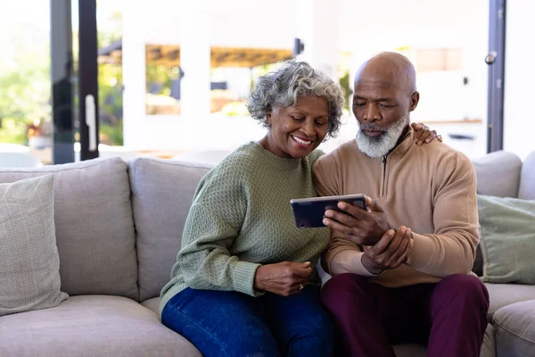 Afrykański Starszy Mężczyzna Kobietą Oglądającą Wideo Przez Cyfrowy Tablet Kanapie — Zdjęcie stockowe