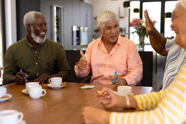 多种族快乐的老年人在餐桌与朋友玩宾果游戏时大显身手 疗养院 休闲游戏 不变的 在一起 辅助生活 — 图库照片