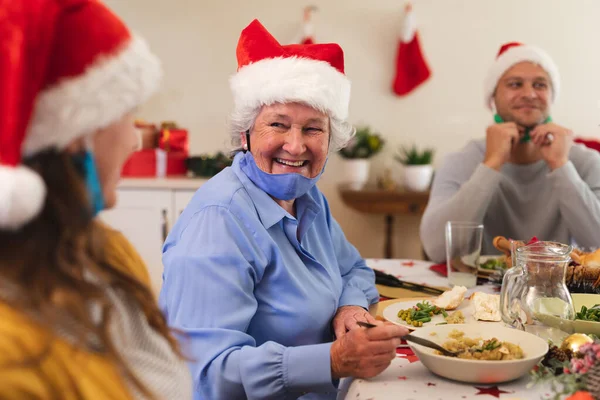 Beyaz Kadın Akşam Yemeği Için Masada Oturuyor Noel Baba Şapkası — Stok fotoğraf
