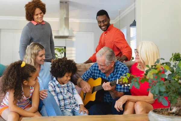 Multiracial Feliz Família Multigeração Olhando Para Homem Sênior Tocando Guitarra — Fotografia de Stock