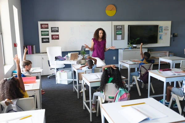 Maestra Joven Caucásica Mirando Estudiantes Primaria Multirracial Con Mano Levantada —  Fotos de Stock