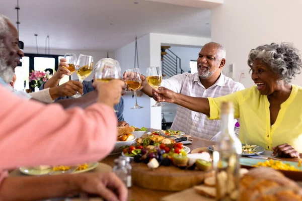 Веселі Багаторасові Старші Друзі Готують Вино Обідаючи Обіднім Столом Будинку — стокове фото