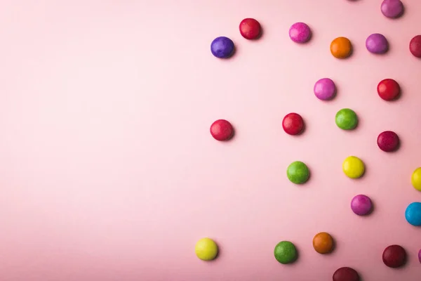 彩色巧克力糖果在粉色背景上被复制空间分散的俯视图 不变的 不健康的饮食和甜食概念 — 图库照片