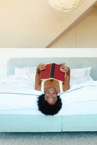 Портрет Африканської Американської Дівчини Яка Посміхається Тримаючи Книжку Ліжку Вдома — стокове фото