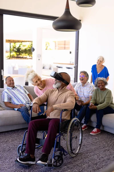 快乐的多种族老年人坐在轮椅上 用虚拟现实来看待朋友 未来主义 辅助生活 养老院 — 图库照片