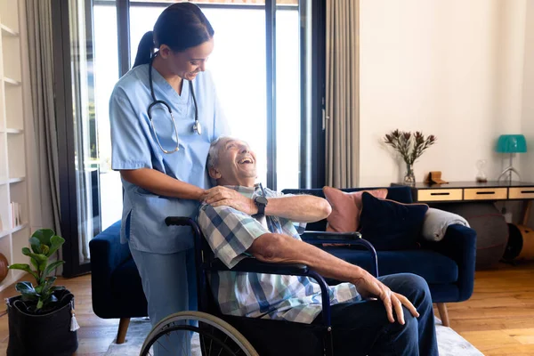 車椅子に座っている白人の老人をサポートする出産女性の健康労働者 医療と定年退職シニアライフスタイルの概念 — ストック写真