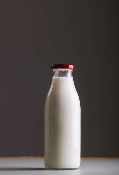 Milk in glass bottle against gray background with copy space. unaltered, food, drink, studio shot and healthy food concept.