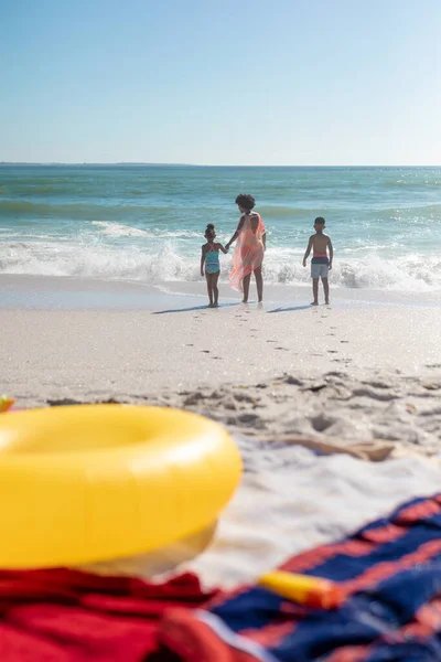 青い空を背景に海岸で波を楽しむ子供たちとアフリカ系アメリカ人の母親 コピースペース 変更されていない ライフスタイル 一緒に 楽しさと休日のコンセプト — ストック写真