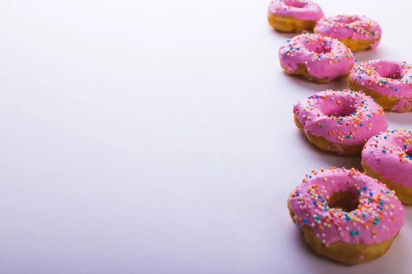 白い背景の上にコピースペースのある新鮮なピンクのドーナツの高い角度ビュー 変化のない不健康な食生活と甘い食の概念 — ストック写真