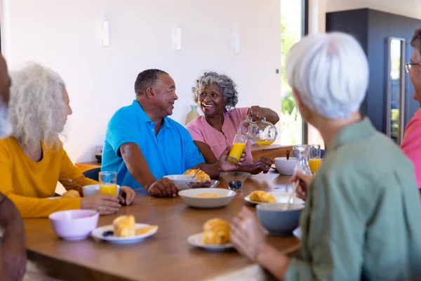 Multiraciala Seniorer Tittar Lycklig Kvinna Som Serverar Juice Till Mannen — Stockfoto
