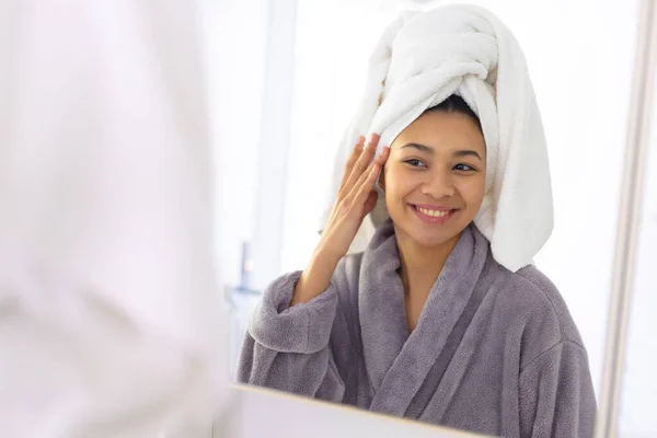 Mulher Biracial Feliz Vestindo Roupão Toalha Olhando Espelho Banheiro Sorrindo — Fotografia de Stock