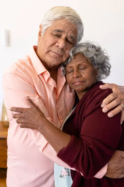 Multiracial Senior Couple Eyes Closed Embracing White Wall Retirement Home — Stock Photo, Image