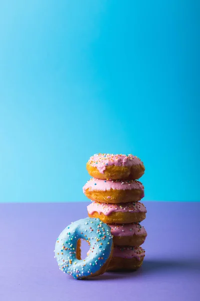 Verse Donuts Met Sprinklers Tegen Een Blauwe Achtergrond Met Kopieerruimte — Stockfoto