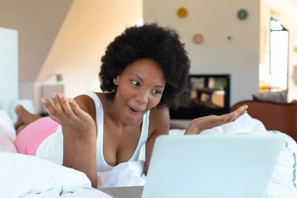 アフリカ系アメリカ人の若いアフロ女性がベッドルームでラップトップを介してビデオ通話中にジェスチャー コピースペース 変更されていない ライフスタイル 家庭や技術の概念 — ストック写真