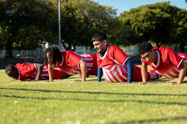 Mannelijke Multiraciale Spelers Rode Uniformen Die Push Ups Doen Gras — Stockfoto