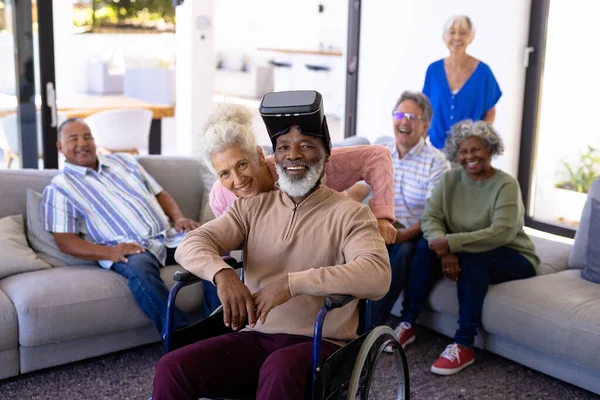 快乐的多种族老年人的画像 男人坐在轮椅上 穿着虚拟现实 未来主义 辅助生活 养老院 — 图库照片