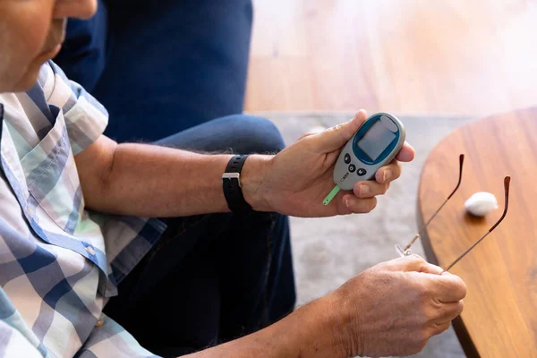 白血病の老人が血糖値を自宅で測定しています 医療と定年退職シニアライフスタイルの概念 — ストック写真