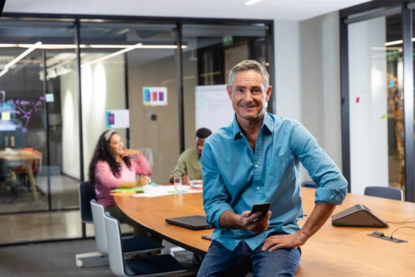 Portrait Smiling Mature Caucasian Businessman Smart Phone While Colleagues Background — Stock Photo, Image