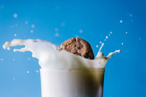 Närbild Spilld Mjölk Med Kaka Glas Mot Blå Bakgrund Kopiera — Stockfoto