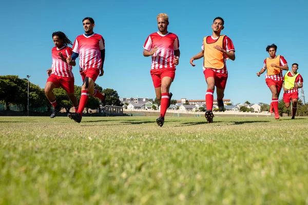 Longitud Completa Atletas Masculinos Multirraciales Uniformes Rojos Corriendo Tierras Herbáceas —  Fotos de Stock