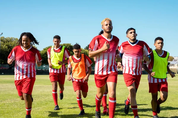 Atletas Masculinos Multirraciales Con Uniformes Deportivos Rojos Corriendo Patio Recreo —  Fotos de Stock