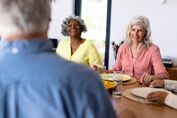 在养老院 多种族的老朋友坐在餐桌边聊天 快乐极了 午餐时间 辅助生活和退休概念 — 图库照片