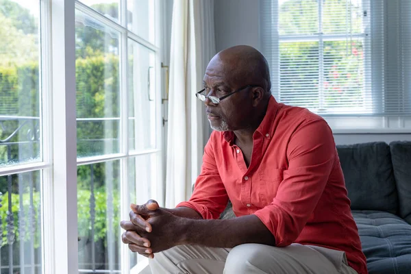 Düşünceli Olgun Afro Amerikan Bir Adam Evinde Oturmuş Pencereye Bakıyor — Stok fotoğraf