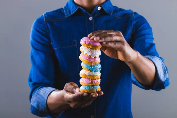 Midsection Homem Americano Africano Que Prende Pilha Fresca Donut Contra — Fotografia de Stock