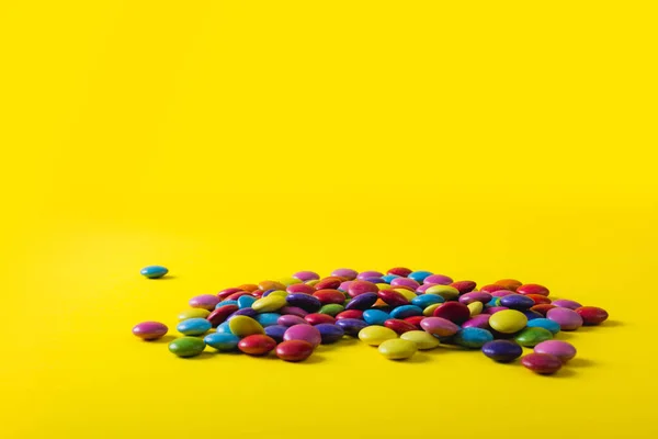 一堆彩色巧克力糖果 黄色背景上有复制空间 不变的 不健康的饮食和甜食概念 — 图库照片